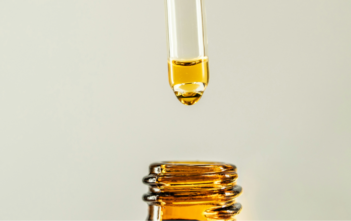 A liquid dropper full of yellow liquid.